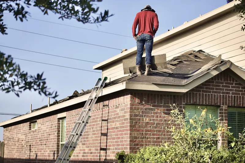 Professional roofer working on a residential roof in Apiary